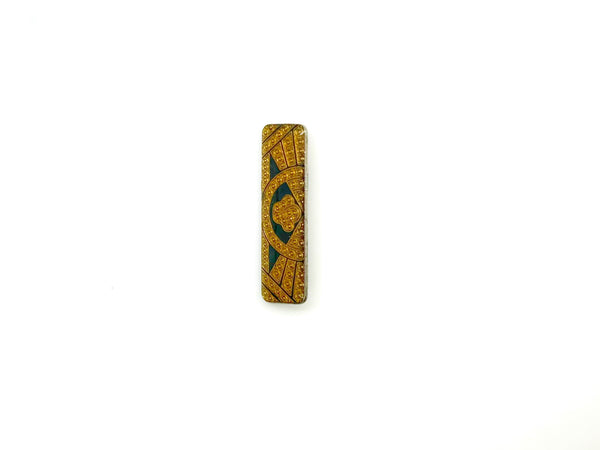 A vintage rectangular Art Deco revival bar brooch in the Pierre Bex style, featuring textured gold-tone metal sunburst rays, dark enamel details, and a central floral cloud medallion against a solid white background