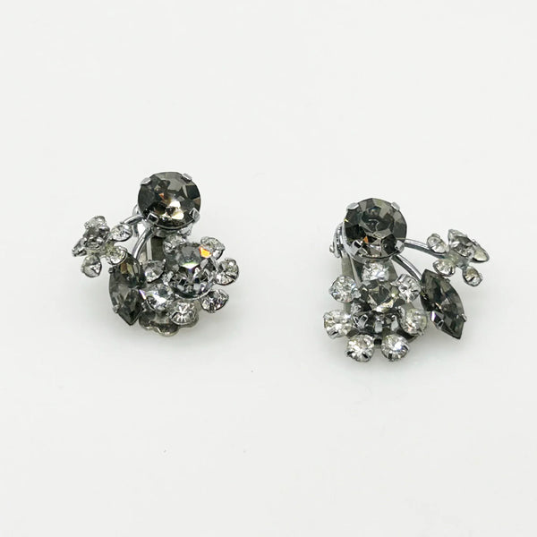These vintage Sparkling Gray Austria Rhinestone Earrings captivate with their dazzling brilliance. Featuring a mix of gray and clear rhinestones expertly cut in marquise and round shapes, their intricate arrangement forms an elegant, eye-catching pattern