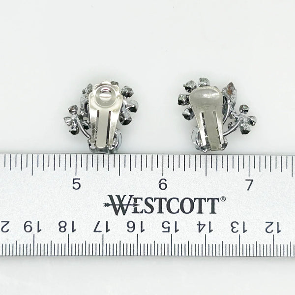 These vintage Sparkling Gray Austria Rhinestone Earrings captivate with their dazzling brilliance. Featuring a mix of gray and clear rhinestones expertly cut in marquise and round shapes, their intricate arrangement forms an elegant, eye-catching pattern