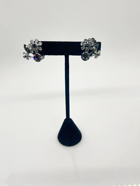 These vintage Sparkling Gray Austria Rhinestone Earrings captivate with their dazzling brilliance. Featuring a mix of gray and clear rhinestones expertly cut in marquise and round shapes, their intricate arrangement forms an elegant, eye-catching pattern