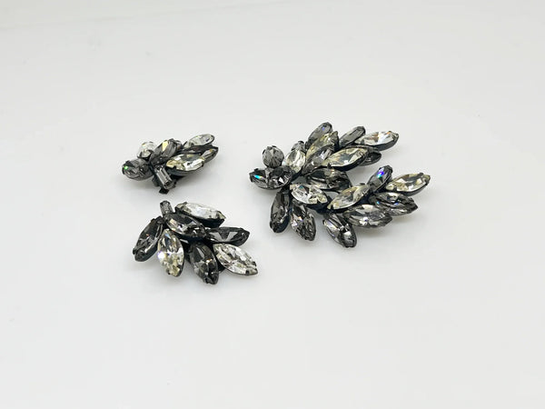 This is a gorgeous set of pin and earrings made with marquise and round shaped rhinestones in gray and clear. They are nestled in a layered, dark metal setting. The stones are standout bright and very sparking, great condition other than some wear on reverse. The earrings are clip on, hinge back.