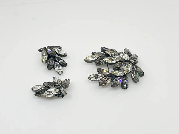 This is a gorgeous set of pin and earrings made with marquise and round shaped rhinestones in gray and clear. They are nestled in a layered, dark metal setting. The stones are standout bright and very sparking, great condition other than some wear on reverse. The earrings are clip on, hinge back.