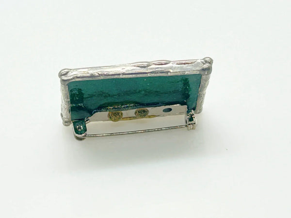 This charming stained glass pin celebrates individuality with a puzzle piece design crafted using authentic Tiffany-style copper foil work. Vibrant green and blue glass pieces are carefully soldered together to create a wearable conversation starter that doubles as meaningful advocacy.