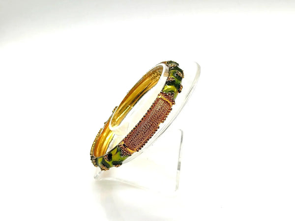 A pair of traditional Indian gold-plated bangles showcasing intricate filigree work and vibrant grass green enamel detailing.