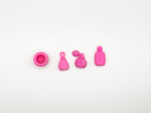 Four small pink accessory charms or beads arranged in a row on a plain white background, including a round lid, a tassel-like piece, a textured pouch-like piece, and a bottle-shaped piece.