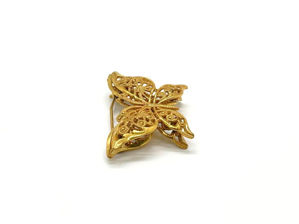 Vintage Miriam Haskell jewelry collection: A signed Russian gold-plated filigree butterfly pin from the 1950s with detailed openwork wings.