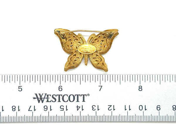 Vintage Miriam Haskell jewelry collection: A signed Russian gold-plated filigree butterfly pin from the 1950s with detailed openwork wings.