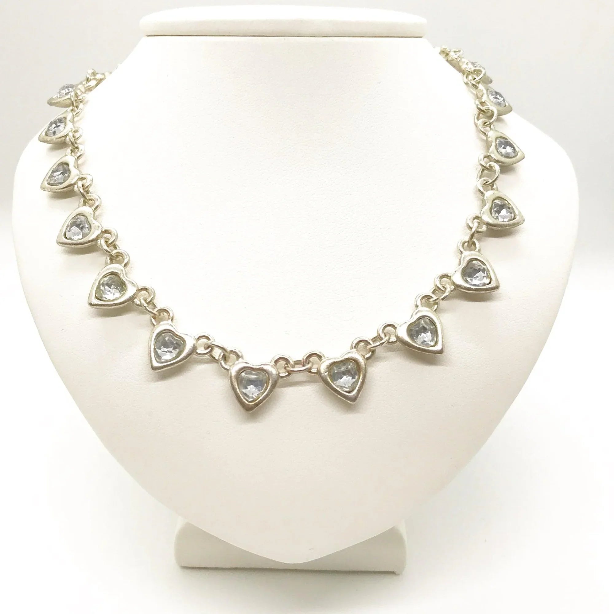 This charming necklace features heart shapes with sparkling round rhinestones at the center. Flip it over to reveal solid hearts with a sleek brushed finish—wear it whichever way suits your mood! Measuring 16" long, it’s secured with an adjustable whimsical flower clasp and a trusty lobster closure for a fun, flirty touch.