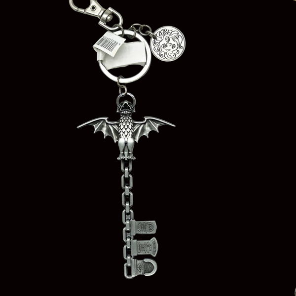 Metallic keychain with bat design and chain on a black background