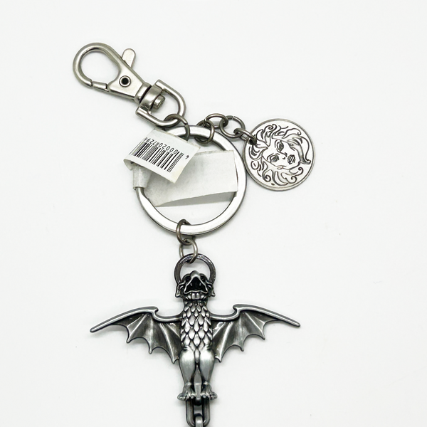 Silver keychain with bat and skull design on a white background