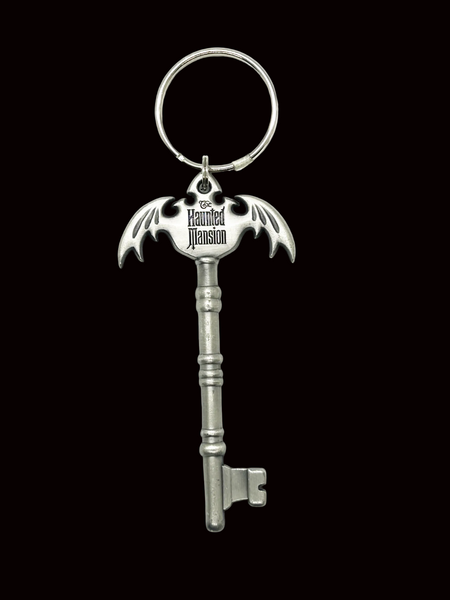 Key-shaped keychain with bat design and 'The Haunted Mansion' text on a black background