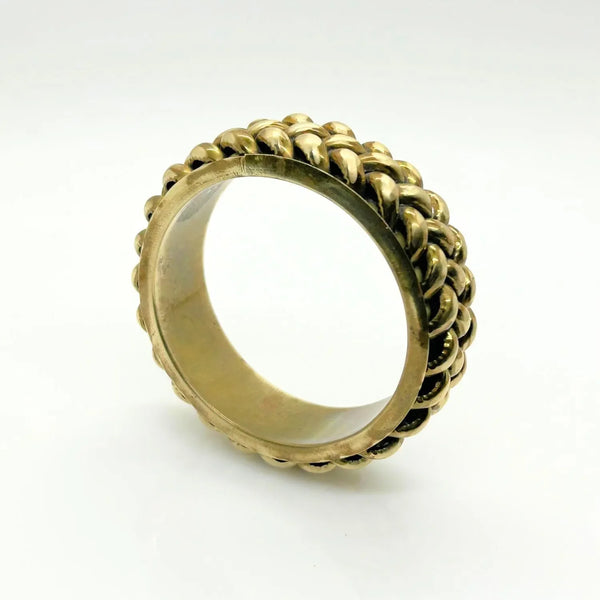 This exquisite vintage bangle bracelet is a captivating piece, showcasing the artistry of three meticulously crafted brass braids elegantly set upon a substantial, weighty metal base. The enchanting golden finish, combined with a perfect 1" vertical height, ensures this bracelet is not only visually stunning but also remarkably versatile, beautifully complementing a wide array of wrist sizes