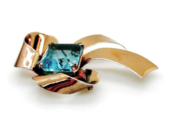 Indulge in timeless elegance with our Vintage Sterling Bow Brooch. The magnificent bow design is adorned with a stunning, clear aqua blue stone, offering a touch of luxury to any outfit. Crafted with precision, this brooch is marked sterling and measures 3 x 2 1/2”, proving to be a truly exclusive piece.