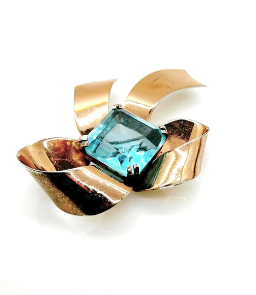 Indulge in timeless elegance with our Vintage Sterling Bow Brooch. The magnificent bow design is adorned with a stunning, clear aqua blue stone, offering a touch of luxury to any outfit. Crafted with precision, this brooch is marked sterling and measures 3 x 2 1/2”, proving to be a truly exclusive piece.