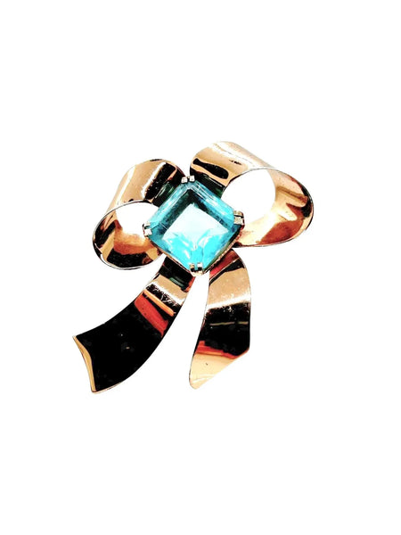 Indulge in timeless elegance with our Vintage Sterling Bow Brooch. The magnificent bow design is adorned with a stunning, clear aqua blue stone, offering a touch of luxury to any outfit. Crafted with precision, this brooch is marked sterling and measures 3 x 2 1/2”, proving to be a truly exclusive piece.