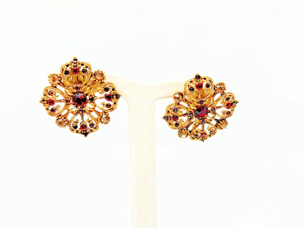 These filigreed vintage red earrings offer an exquisite aesthetic, beautifully detailed with pink, purple, and red chaton rhinestones in a square pattern. Meticulously designed, each earring's dimensions measure 3/4" square. 