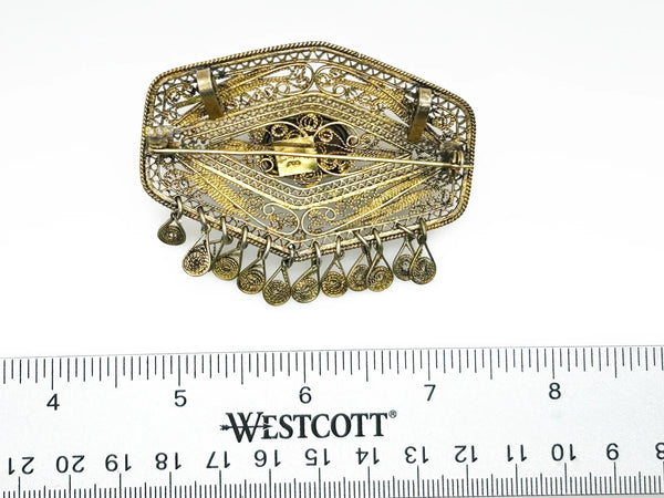 Vintage Israel Filigree Brooch/pendant with Tassels and Smokey Quartz center Stone.It has a geometric shape with tiny filigree drops at the bottom, and a large, faceted oval stone is the centerpiece. The metal is extremely intricate and detailed, both front and back.