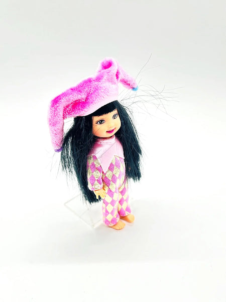 Jester Jenny doll wearing a pink and white checkered outfit with a matching hat on a white background