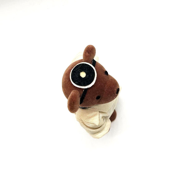 A small brown plush teddy bear dressed up as a medical doctor