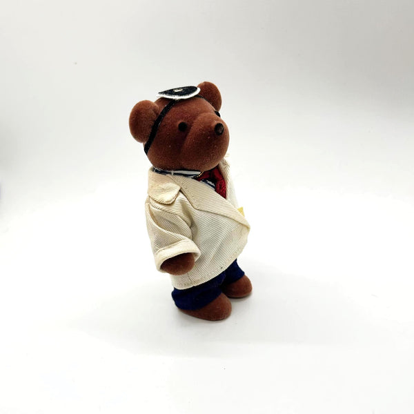 A small brown plush teddy bear dressed up as a medical doctor