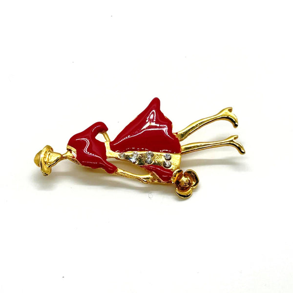 The highlighted item is a vintage enameled lady figural brooch, showing a stylish woman dressed in a vibrant red coat or dress with a wide-brimmed hat. 