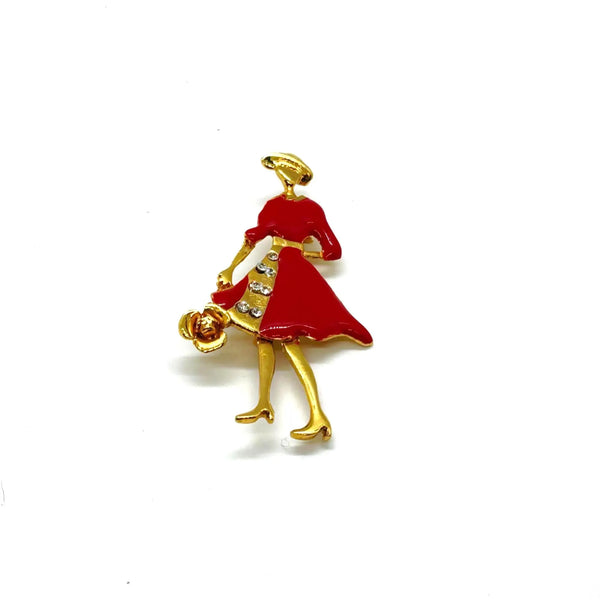 The highlighted item is a vintage enameled lady figural brooch, showing a stylish woman dressed in a vibrant red coat or dress with a wide-brimmed hat. 