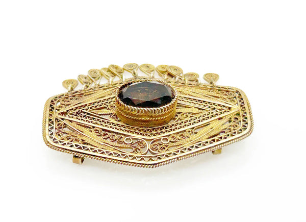 Vintage Israel Filigree Brooch/pendant with Tassels and Smokey Quartz center Stone.It has a geometric shape with tiny filigree drops at the bottom, and a large, faceted oval stone is the centerpiece. The metal is extremely intricate and detailed, both front and back.