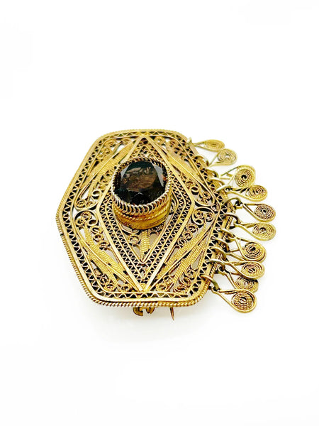Vintage Israel Filigree Brooch/pendant with Tassels and Smokey Quartz center Stone.It has a geometric shape with tiny filigree drops at the bottom, and a large, faceted oval stone is the centerpiece. The metal is extremely intricate and detailed, both front and back.