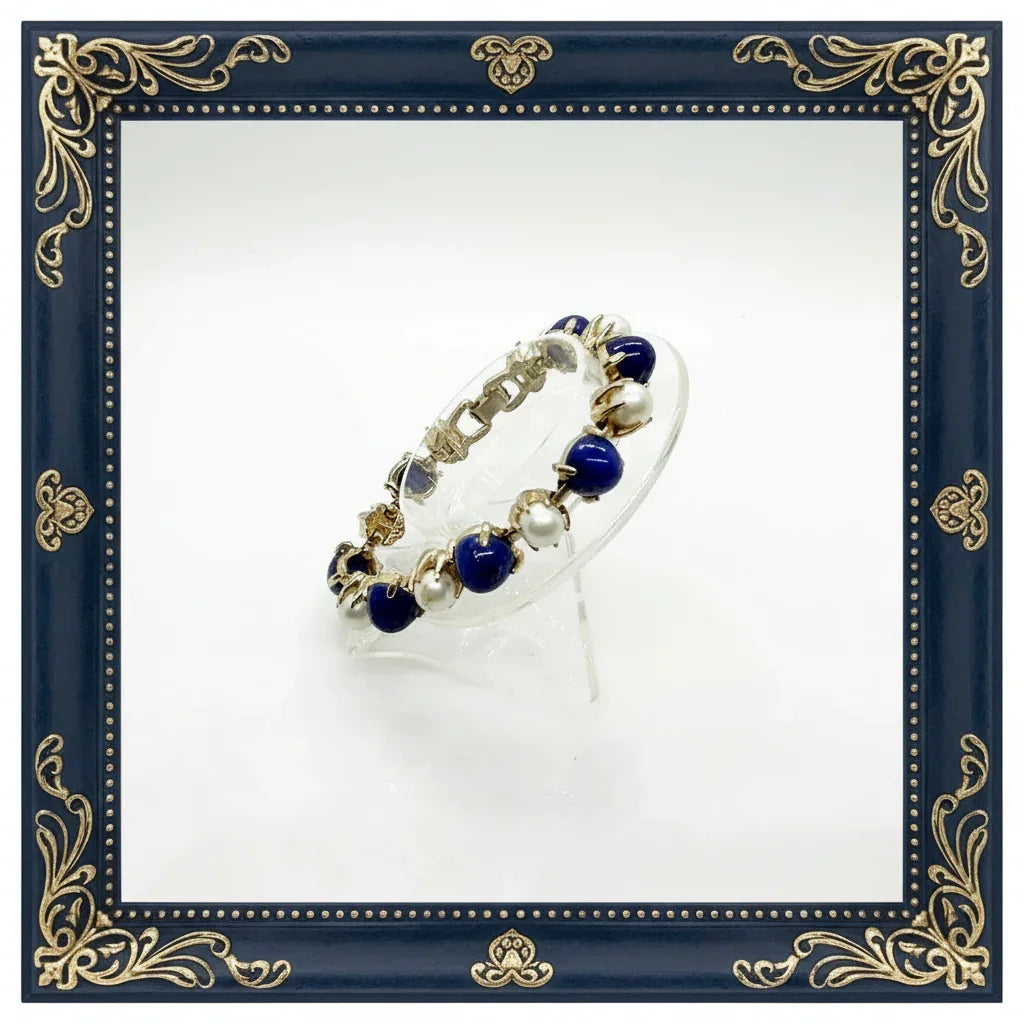 This exquisite vintage bracelet combines timeless elegance with striking visual appeal. Featuring alternating domed lapis-style stones in rich deep blue tones paired with lustrous faux pearls, all set in warm gold-tone metal, it's a statement piece that elevates any ensemble.