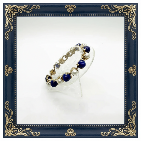 This exquisite vintage bracelet combines timeless elegance with striking visual appeal. Featuring alternating domed lapis-style stones in rich deep blue tones paired with lustrous faux pearls, all set in warm gold-tone metal, it's a statement piece that elevates any ensemble.