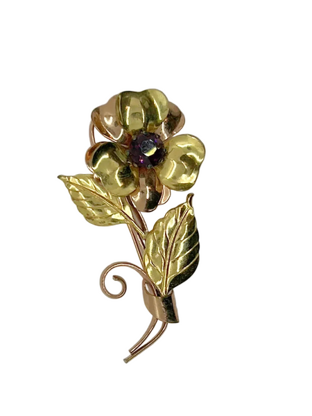 Bring a touch of vintage glamour to any outfit with this stunning, handmade flower brooch. Its beautifully crafted copper and gold petals and leaves surround a sparkling purple center, making it a striking statement piece that will surely turn heads.