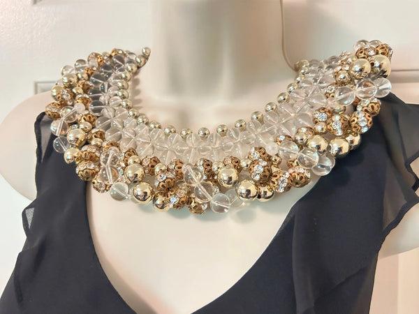 Add a touch of glamour to your wardrobe with this one-of-a-kind statement piece. Crafted with heavy glass and gold beads, this collar necklace boasts intricate rows of round gold beads, graduated clear beads, and rhinestone-studded rondelles for an eye-catching effect.