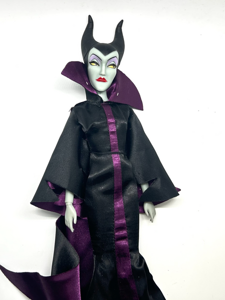 Disney Store Maleficent 12-inch classic fashion doll wearing her iconic black and burgundy robe with curved horns headpiece, isolated on a solid white background.