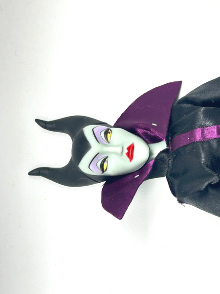 Disney Store Maleficent 12-inch classic fashion doll wearing her iconic black and burgundy robe with curved horns headpiece, isolated on a solid white background.