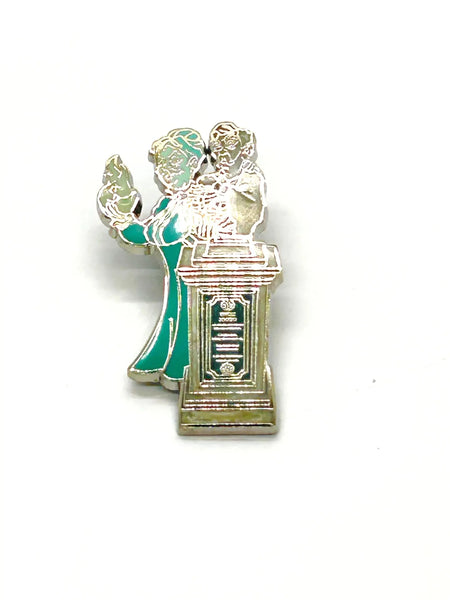 This pin is a 2012 Disney Parks Walt Disney World Haunted Mansion Interactive Graveyard Queue "Cousin Maude and Uncle Jacob's Statue" mystery pin.