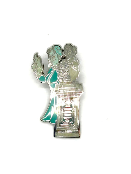This pin is a 2012 Disney Parks Walt Disney World Haunted Mansion Interactive Graveyard Queue "Cousin Maude and Uncle Jacob's Statue" mystery pin.