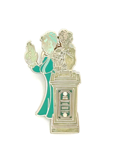 This 2012 mystery pin celebrates the interactive Graveyard Queue at Magic Kingdom's Haunted Mansion. It features "Cousin Maude and Uncle Jacob's Statue"