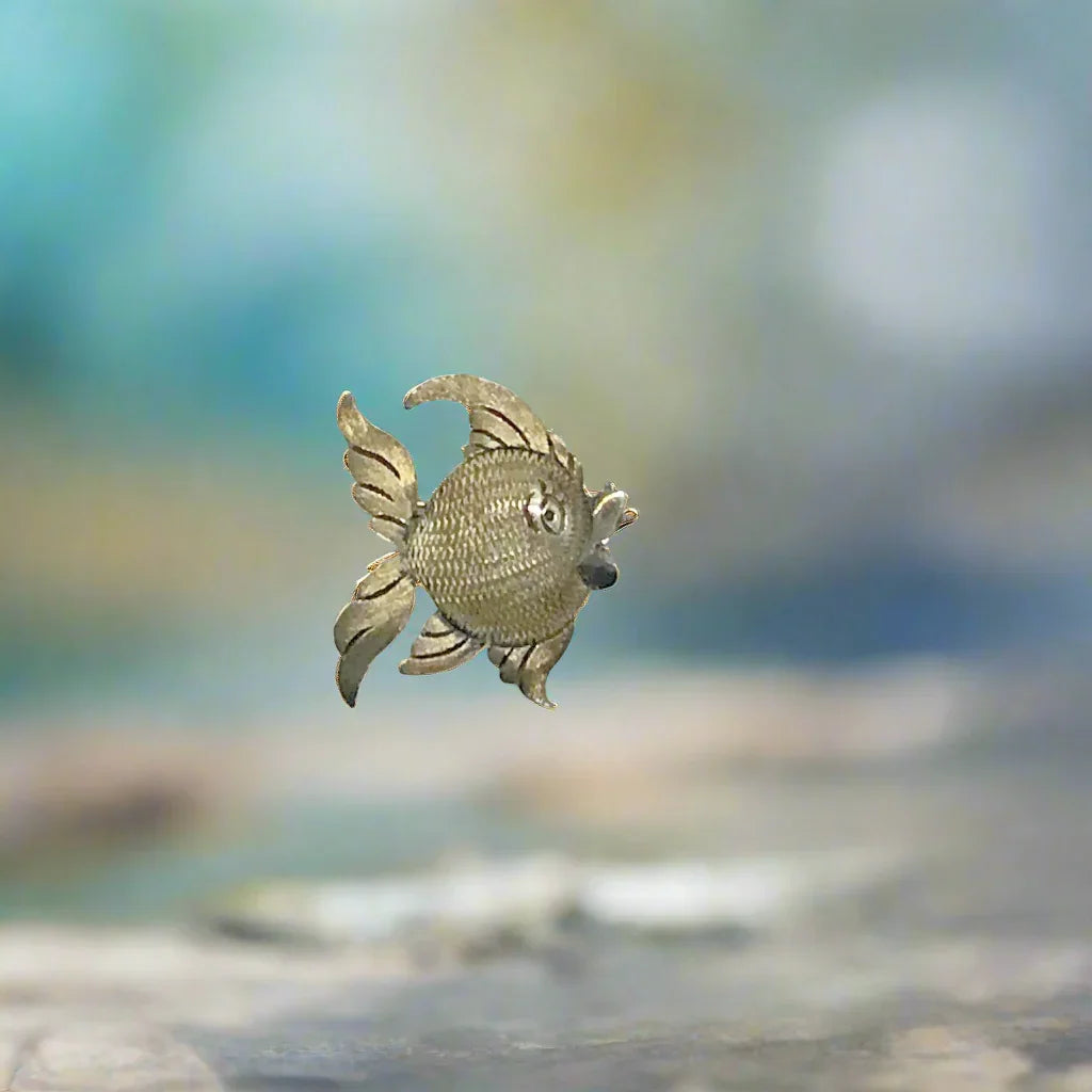 This is a whimsical brooch in the shape of a fish. The detailing on the scales and fins is particularly nice. It measures 1.25” across. Add a touch of charm to any outfit with our Vintage Mexican Silver Fish Brooch. You'll love the intricate detailing on the scales and fins, giving it a unique and whimsical touch. At 1.25" across, it's the perfect size for everyday wear.