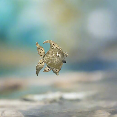 This is a whimsical brooch in the shape of a fish. The detailing on the scales and fins is particularly nice. It measures 1.25” across. Add a touch of charm to any outfit with our Vintage Mexican Silver Fish Brooch. You'll love the intricate detailing on the scales and fins, giving it a unique and whimsical touch. At 1.25" across, it's the perfect size for everyday wear.