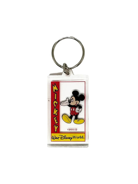 This Mickey Mouse keychain perfectly shows off Mickey's exuberant and friendly spirit. It is made of clear acrylic, and shows Mickey in his trademark red shorts with white buttons, white gloves and yellow shoes. He smiles broadly and extends a welcoming hand- the classic depiction of Mickey.