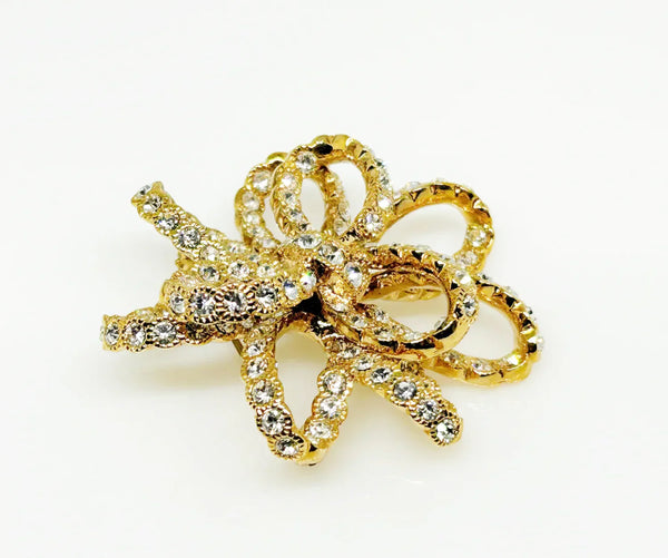 Discover a rare glamour brooch by Nolan Miller, a super sparkly 3D ribbon design in rich gold metal with bright clear stones. Free shipping included!