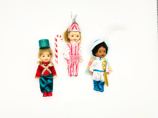 Front view of a 2001 Mattel Barbie in the Nutcracker Kelly Club multi-doll collectible set. The 3-doll lot includes miniature character figures of Tommy in a red toy soldier outfit, Kelly with blonde hair in a peppermint stripe dress, and an African American Tommy figure wearing a white and blue uniform with a golden staff