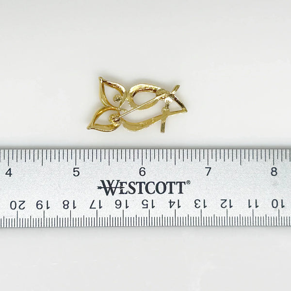 Indulge in the timeless sophistication of this stunning brooch featuring a stylized owl perched on a delicate branch. At 1.5” tall, it is adorned with the iconic Trifari crown. This exquisite piece is crafted to perfection, adding a touch of subtle elegance to any outfit.