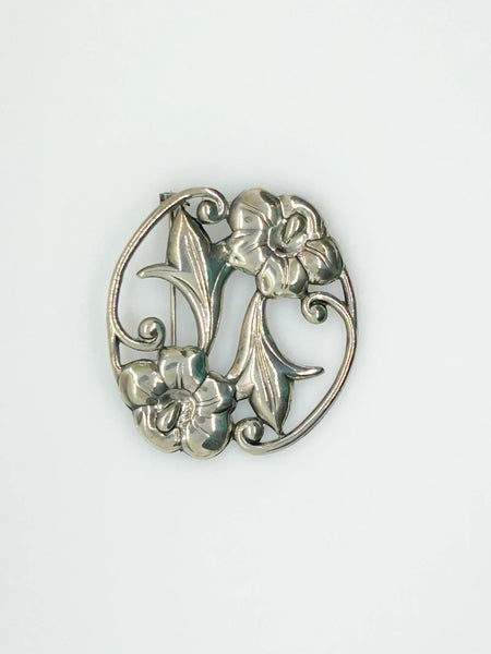 This stunning Art Nouveau floral brooch captivates with two beautiful blooms in an elegant oval shape. 