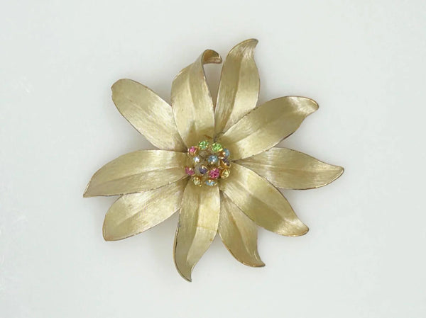 This is an elegant flower brooch which has a trembler center composed of prong set pastel rhinestones. The petals are sculpted and textured on both front and back.