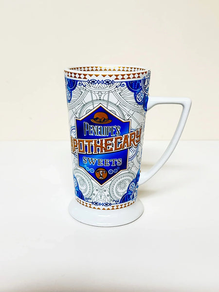 Universal Studios Toothsome Chocolate Emporium Penelope's Apothecary Sweets tall ceramic pedestal mug with blue, white, and gold geometric pattern on a solid white background.