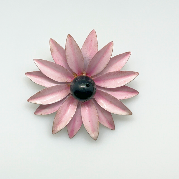 Bring a splash of retro charm to your collection with this delightful 1960s mod brooch! Featuring vibrant pink enamel petals arranged in a bold daisy design, it captures the spirit of the flower power movement that defined the swinging sixties. Shop Now!