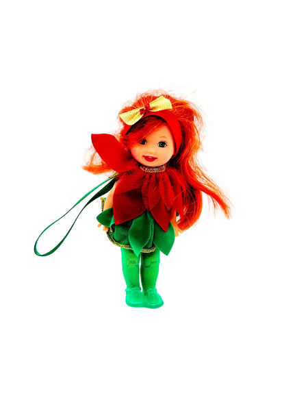  This charming Kelly Club figure features vibrant red hair, festive green tights, and an adorable poinsettia-themed dress that captures the spirit of the season