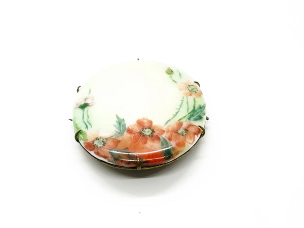 A charming slice of history pinned to your lapel! This delicate porcelain red poppy brooch whispers tales from the Victorian and Edwardian eras, hand-painted with the care artisans devoted to their craft over a century ago.