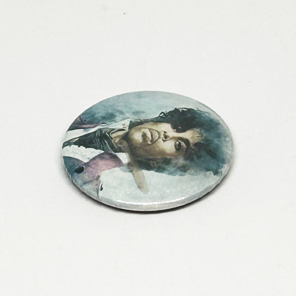 A vintage 1984 Prince pinback button badge featuring a painted portrait of Prince Rogers Nelson during the Purple Rain era